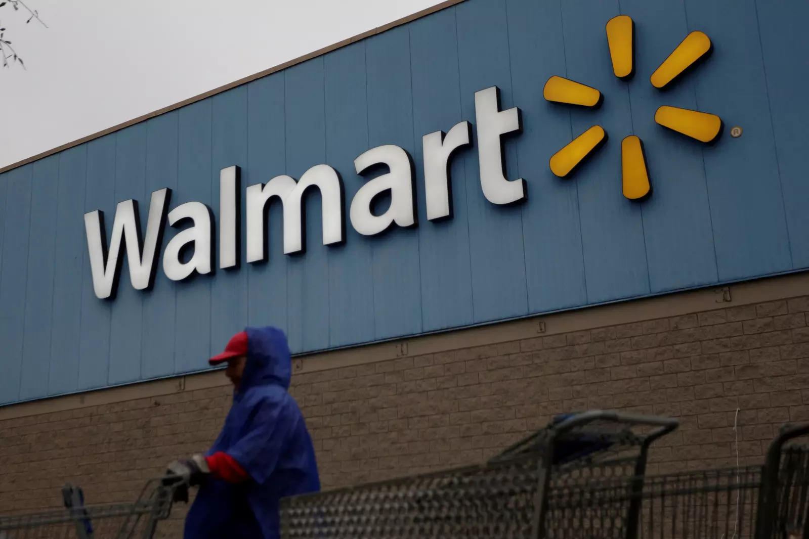 FILE PHOTO: Employee arranges shopping carts in front of the logo of Walmart outside a store in Monterrey